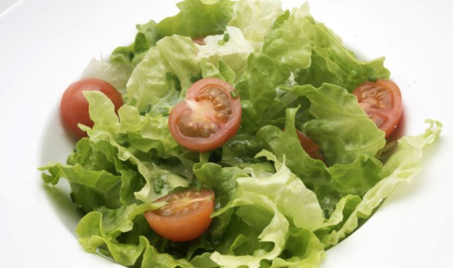 Ensalada de lechuga, cherrys y cebollino con huevos plancha.